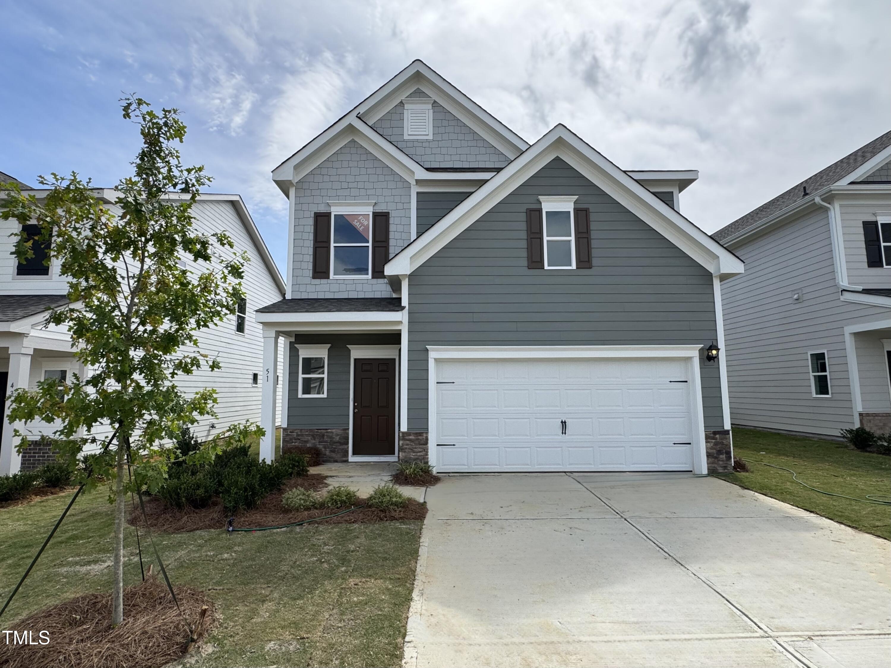 a view of a house with a yard and potted plants
