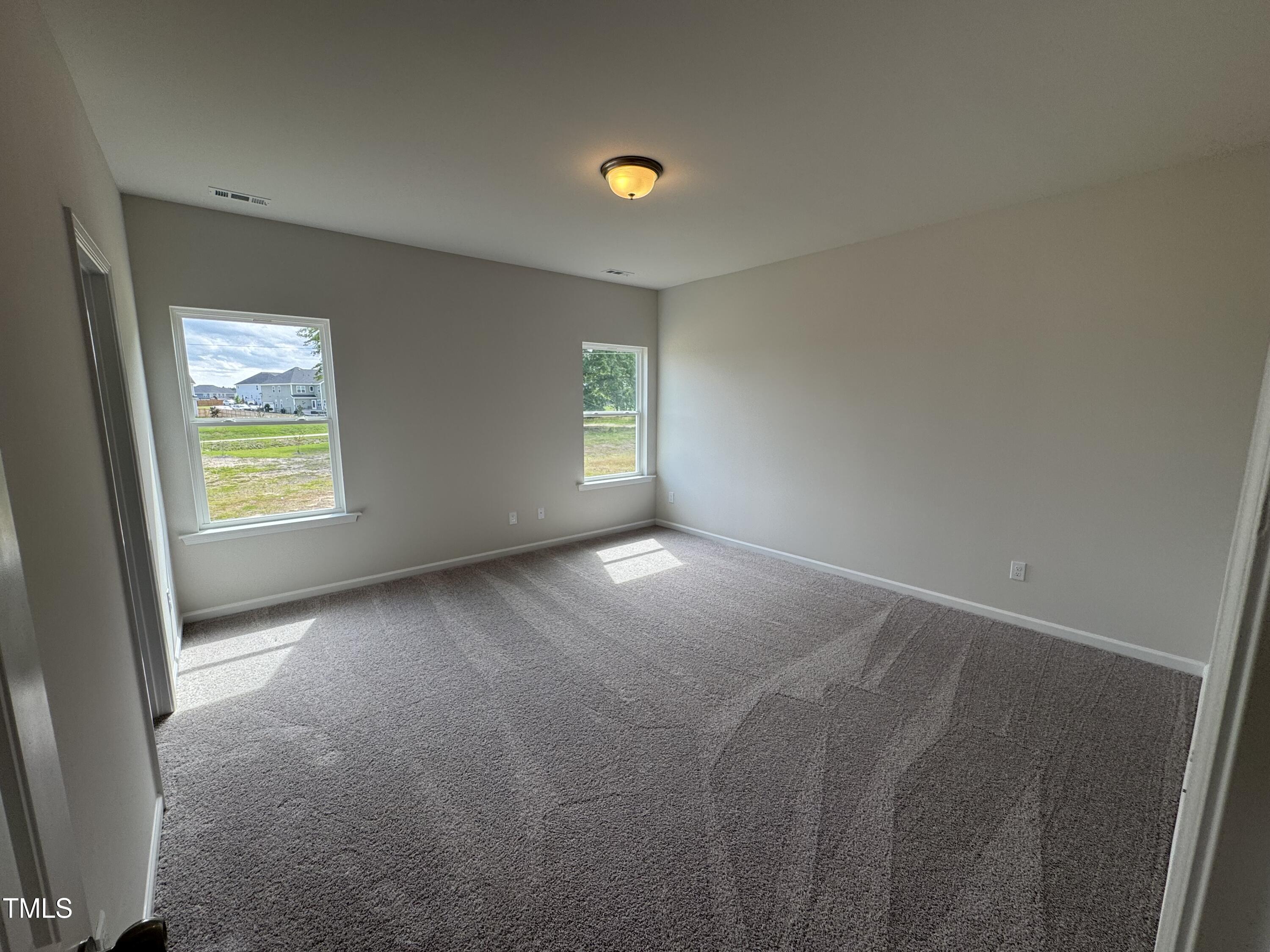 51 Commons Circle Clayton, NC 27520 - Photo 16 of 31 a view of an empty room with window and wooden floor