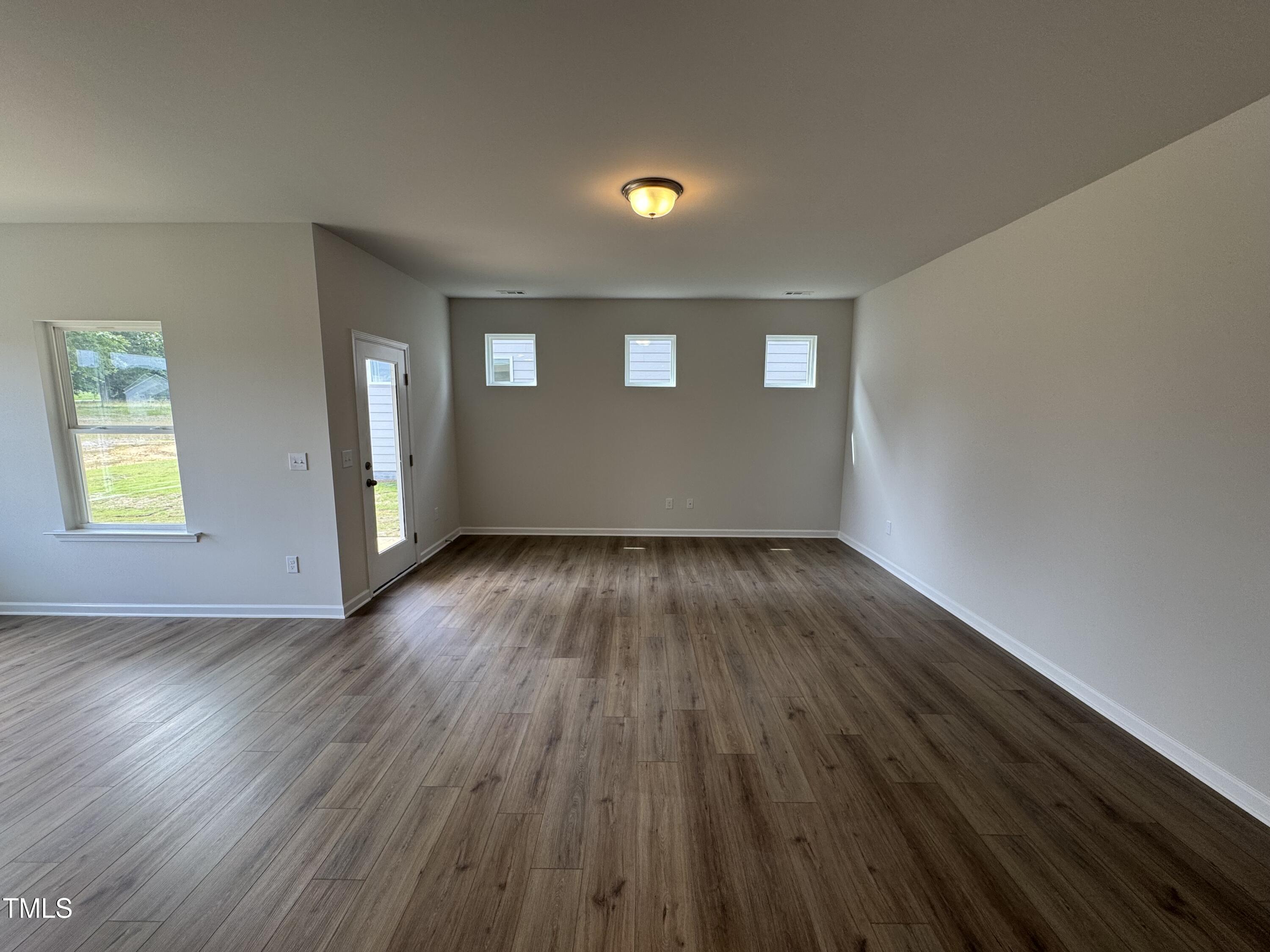 51 Commons Circle Clayton, NC 27520 - Photo 3 of 31 an empty room with wooden floor and windows