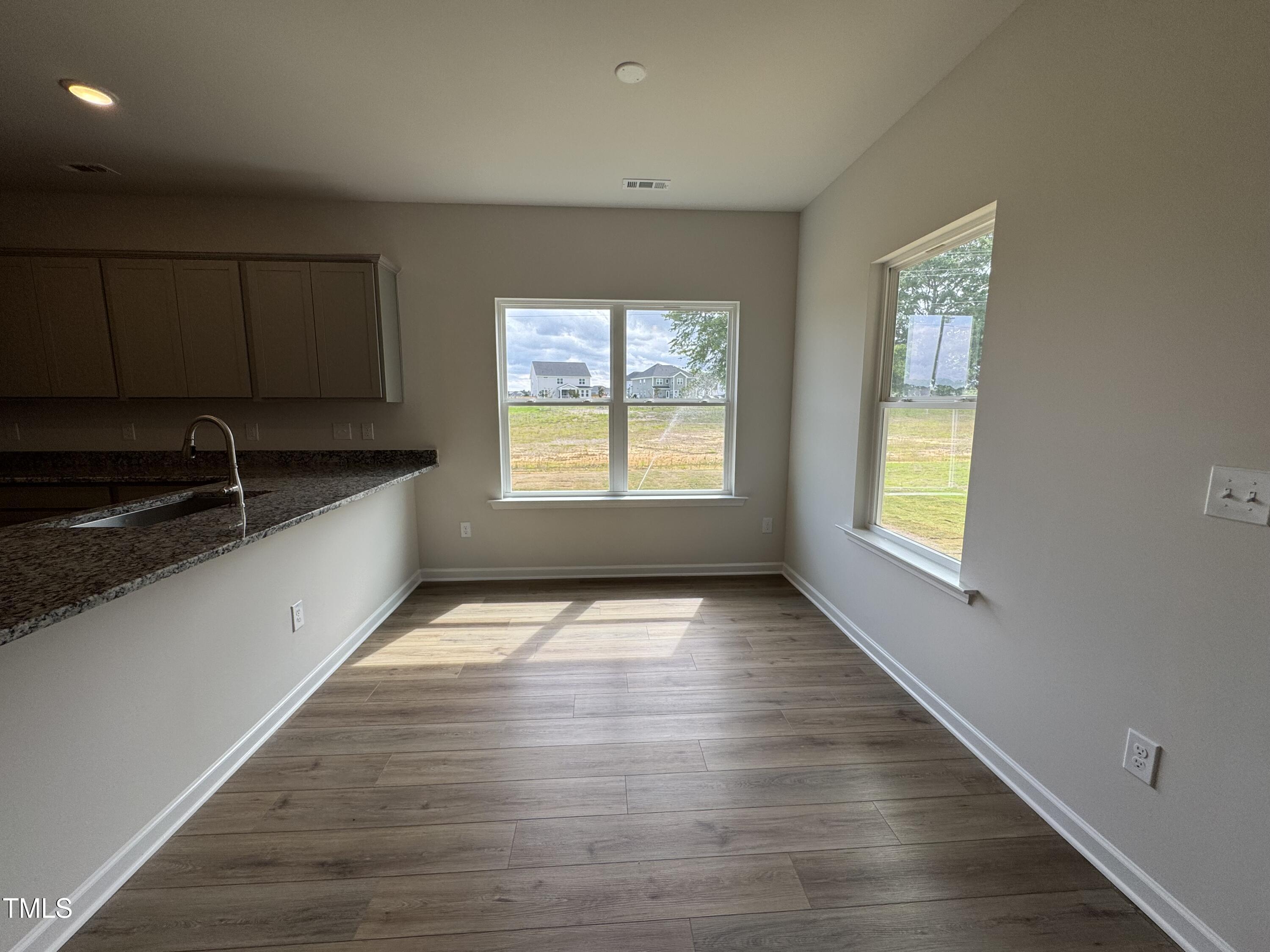 51 Commons Circle Clayton, NC 27520 - Photo 4 of 31 a view of an empty room with window wooden floor and cabinet