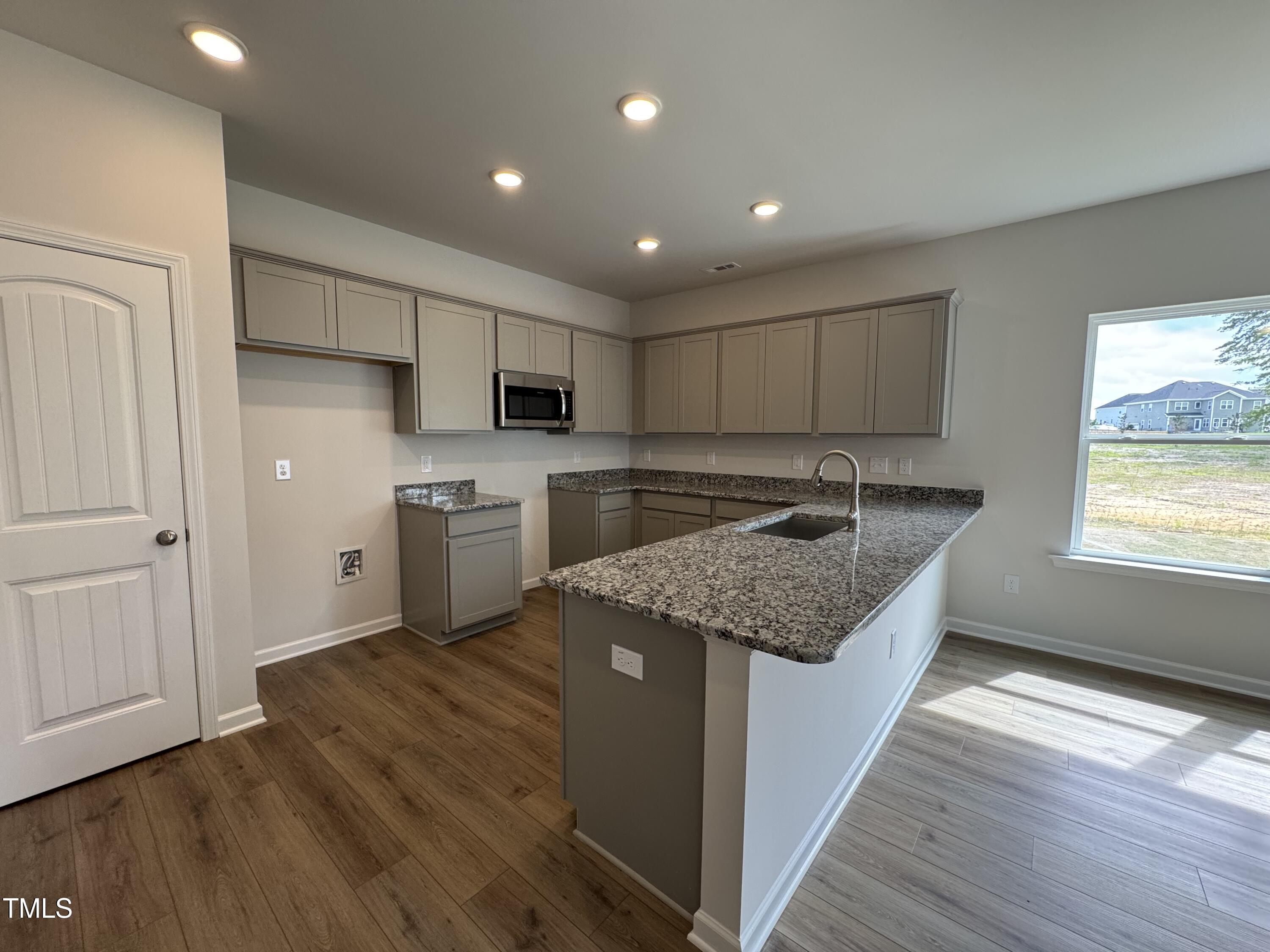 51 Commons Circle Clayton, NC 27520 - Photo 5 of 31 a kitchen with stainless steel appliances granite countertop a sink stove and refrigerator