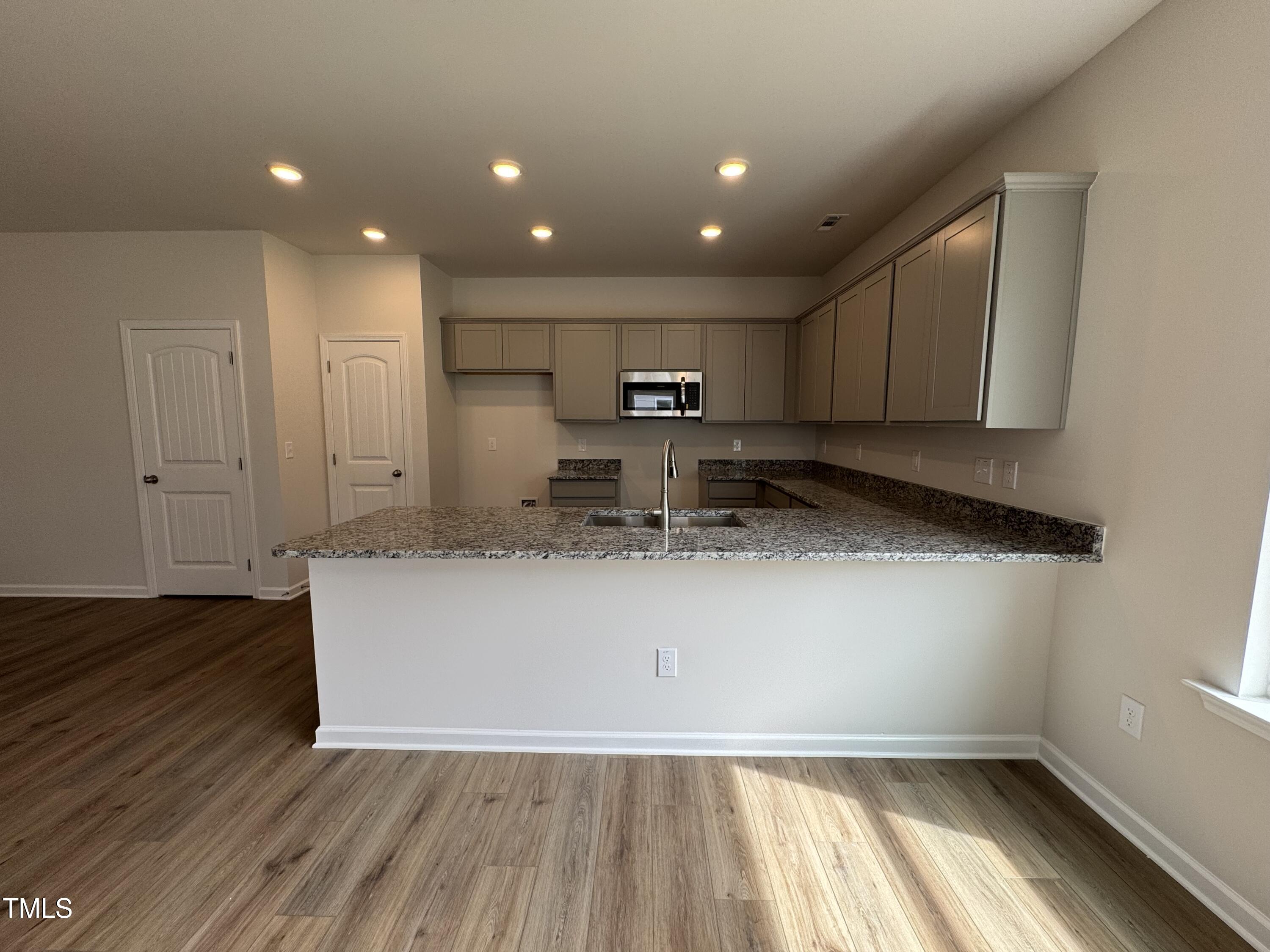51 Commons Circle Clayton, NC 27520 - Photo 7 of 31 a view of kitchen with granite countertop sink and refrigerator