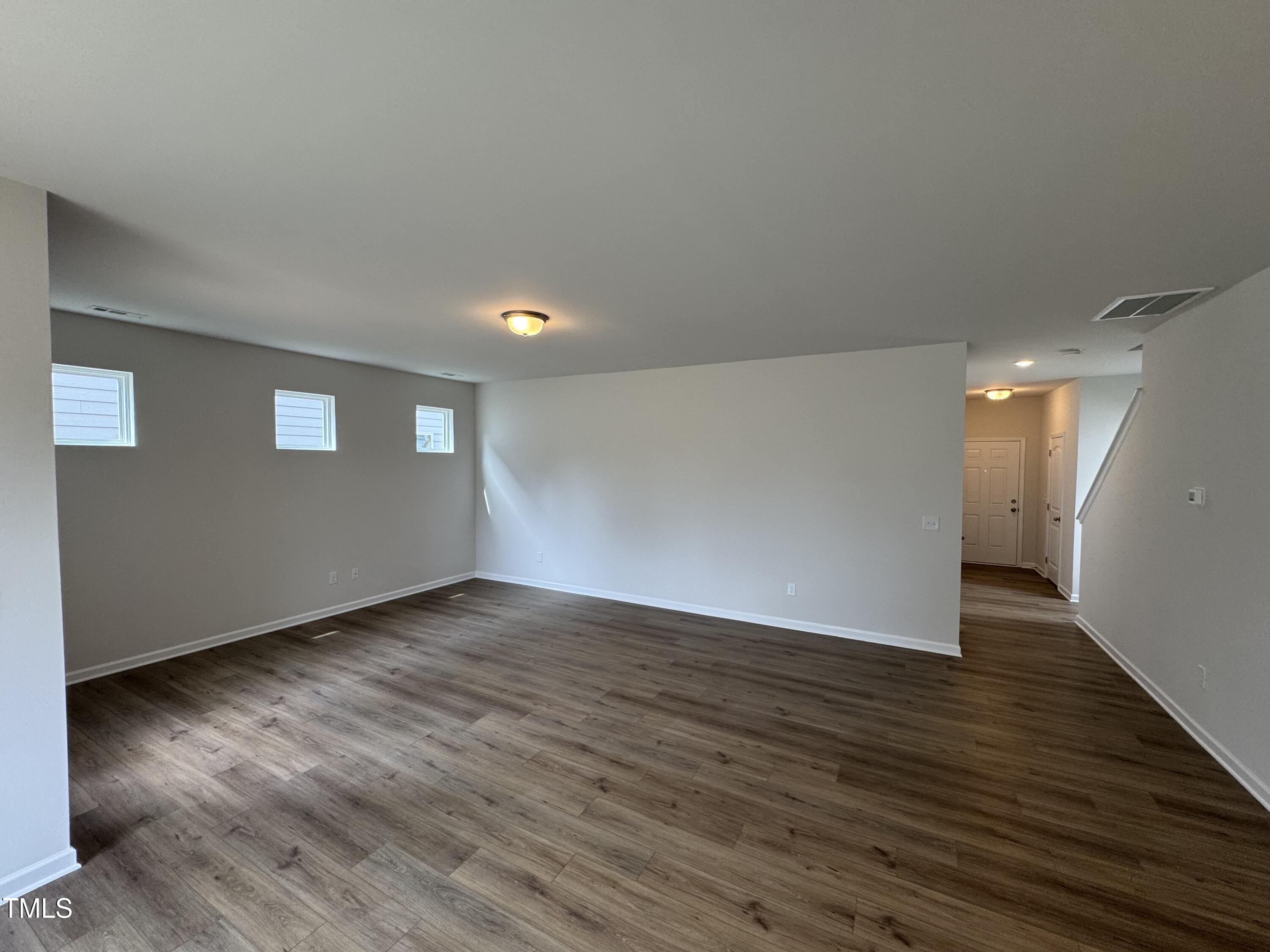 51 Commons Circle Clayton, NC 27520 - Photo 8 of 31 a view of an empty room with wooden floor and a window