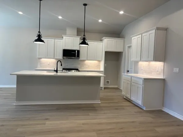 a kitchen with kitchen island a sink stainless steel appliances and cabinets