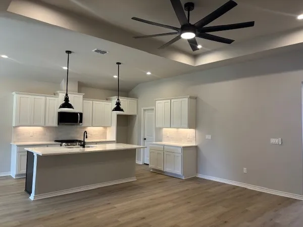 a kitchen with kitchen island white cabinets and stainless steel appliances