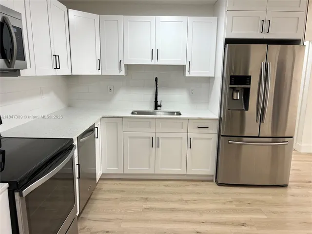 a kitchen with a sink stainless steel appliances and cabinets