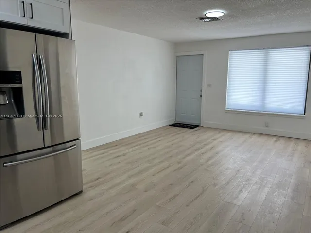 a view of a refrigerator in kitchen and wooden floor