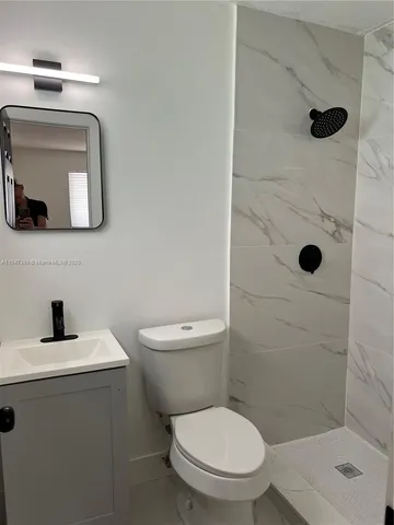 a bathroom with a toilet sink and shower
