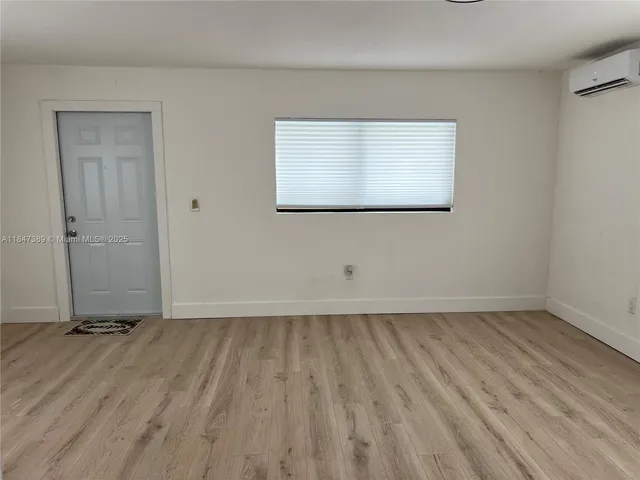 a view of a room with wooden floor and a window