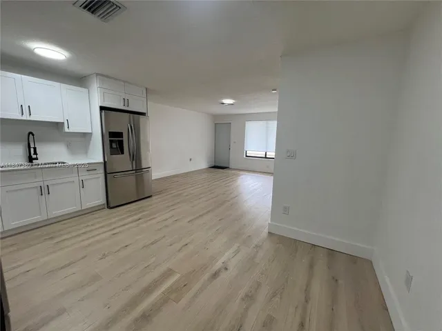 a view of a kitchen with a sink and a refrigerator