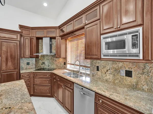 a kitchen with stainless steel appliances granite countertop a sink stove and cabinets