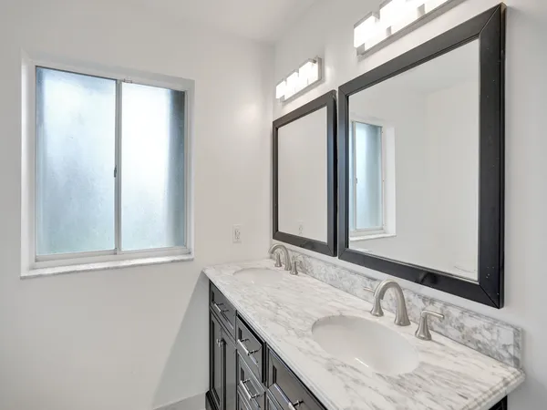 a bathroom with a granite countertop sink and a mirror