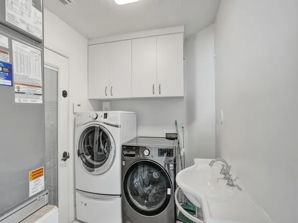 a utility room with sink dryer and washer
