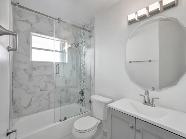 a bathroom with a sink toilet a mirror and shower