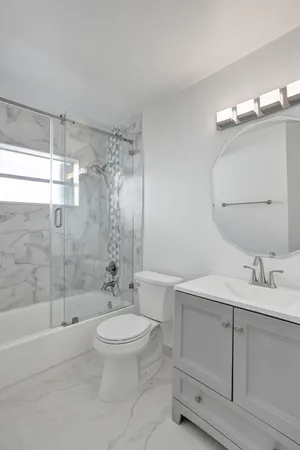 a bathroom with a sink a toilet and shower