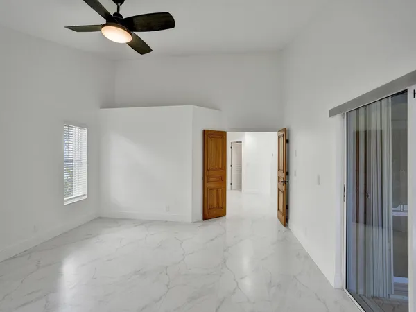a view of a room with an empty space and a ceiling fan