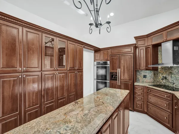 a kitchen with stainless steel appliances kitchen island granite countertop a refrigerator and microwave