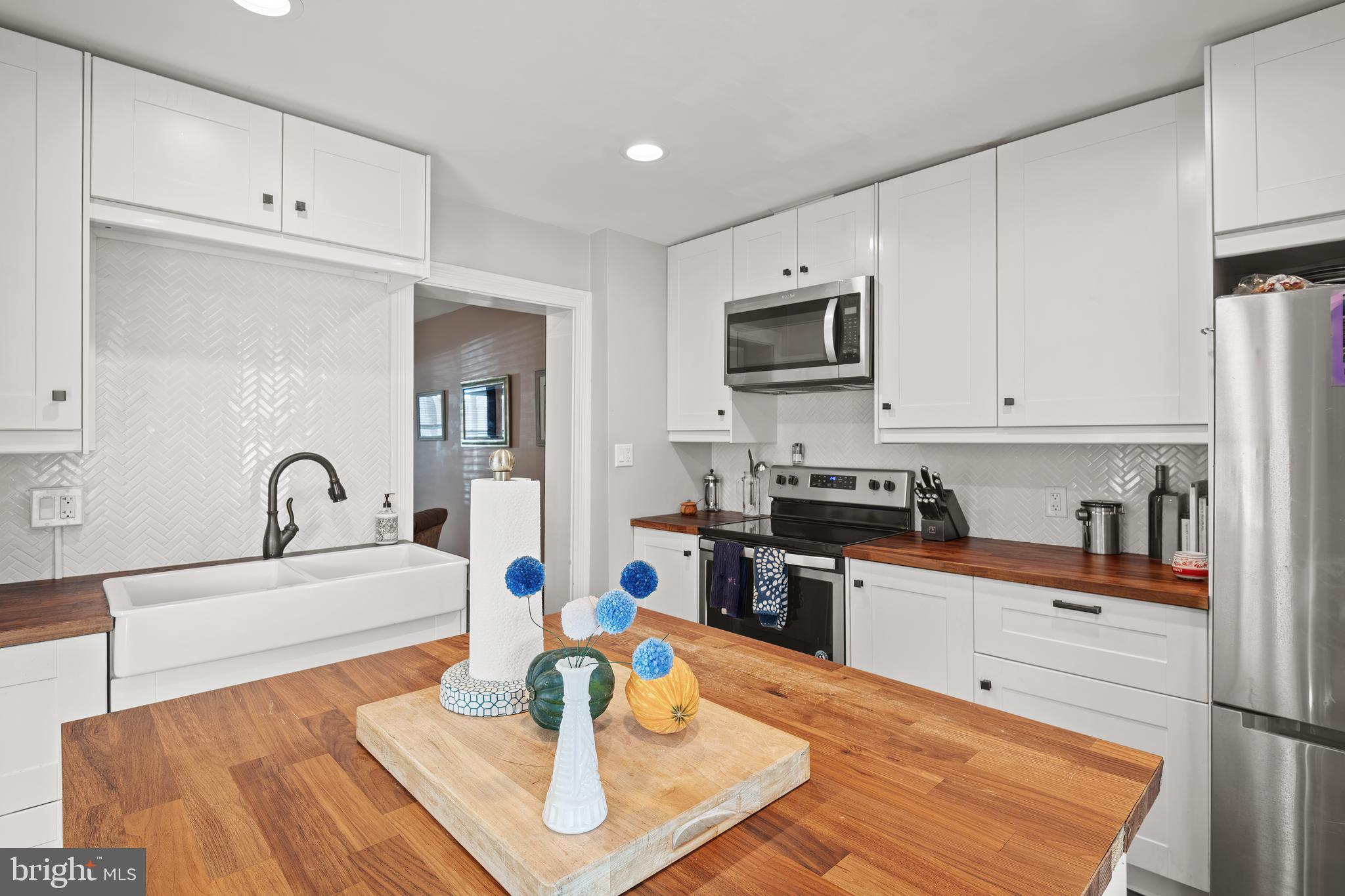 156 Front Street Lititz, PA 17543 - Photo 4 of 58 a kitchen with stainless steel appliances kitchen island granite countertop a sink dishwasher a stove and a refrigerator with wooden floor