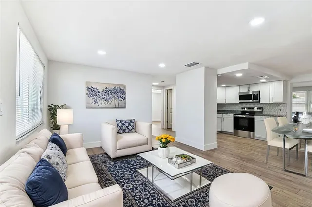 a view of an empty room with wooden floor and window