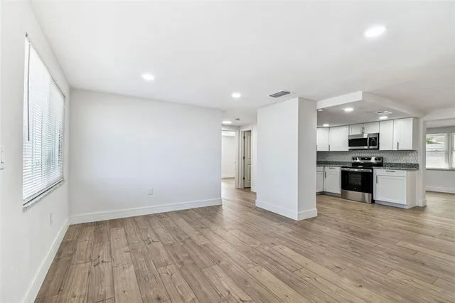 a large kitchen with kitchen island a sink stainless steel appliances and cabinets