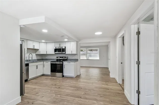 a bedroom with a bed a television and wooden floor