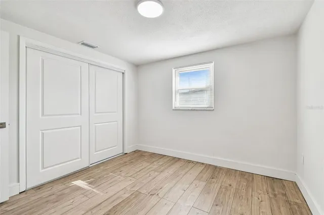 a view of a room with wooden floor and a window