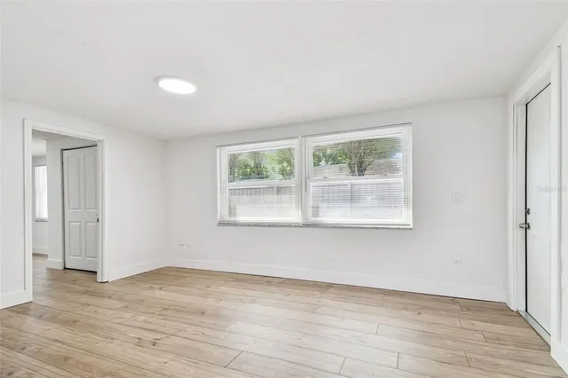 a view of a room that has wooden floor and brick walls