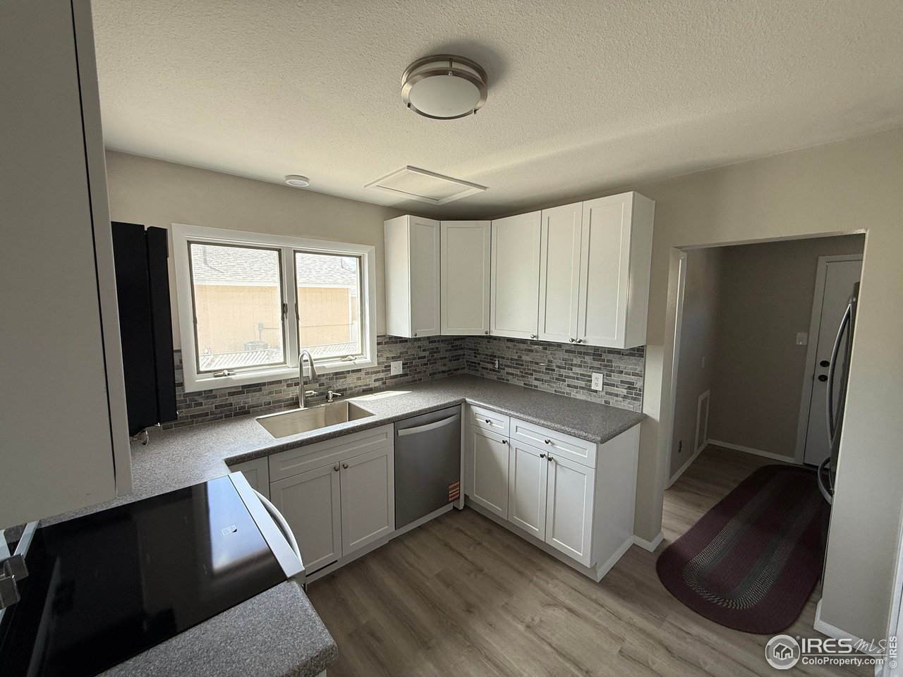 827 Prospect Street Fort Morgan, CO 80701 - Photo 4 of 7 a kitchen with stainless steel appliances granite countertop a sink stove and refrigerator