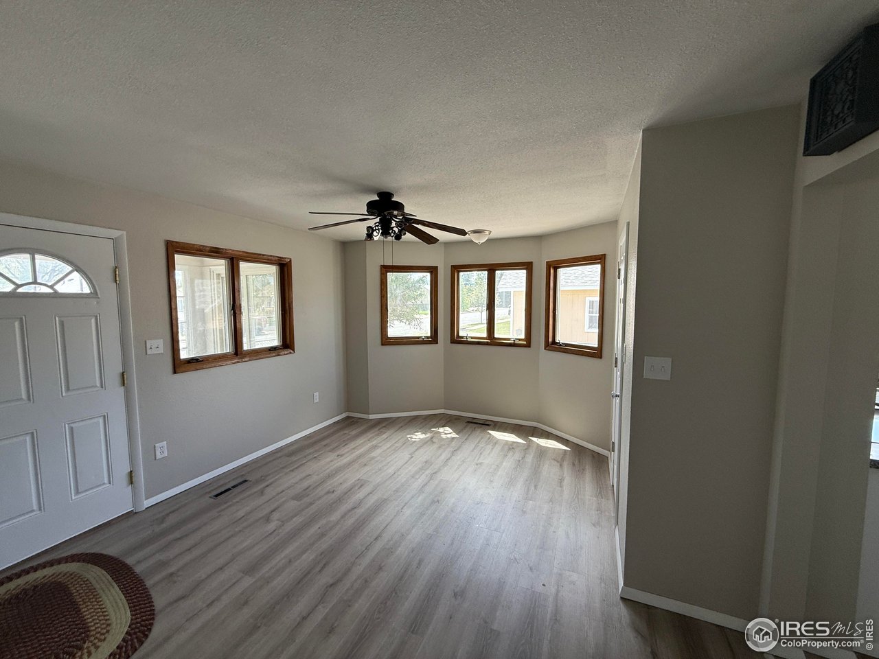 827 Prospect Street Fort Morgan, CO 80701 - Photo 7 of 7 a view of an empty room with a window and wooden floor