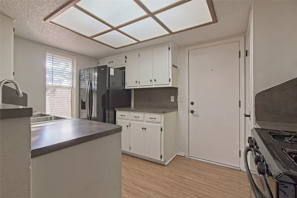 a large kitchen with a large counter top and stainless steel appliances