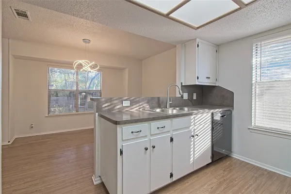 a kitchen with granite countertop a stove a sink and a refrigerator