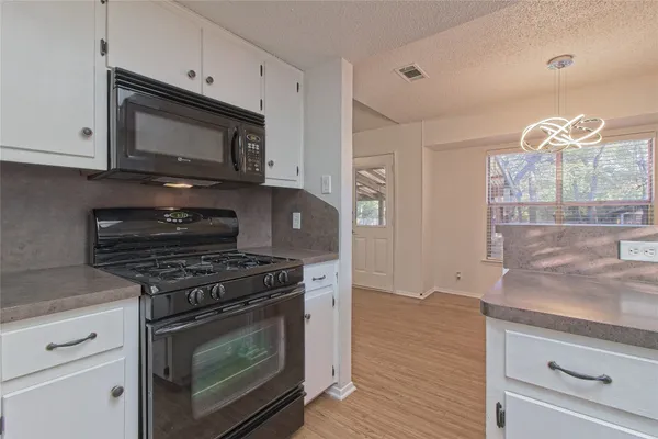 a kitchen with stainless steel appliances granite countertop a stove refrigerator and cabinets