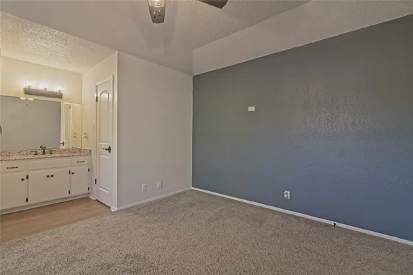 an empty room with chandelier fan