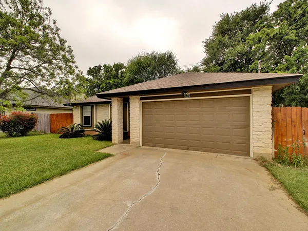 a front view of house with yard and trees around
