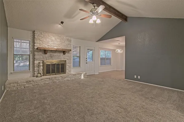 a view of a livingroom with a fireplace and a chandelier fan