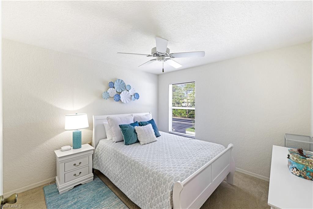 386 Emerald Bay Circle, Unit G4 Naples, FL 34110 - Photo 20 of 22 a bedroom with a large bed and a chandelier