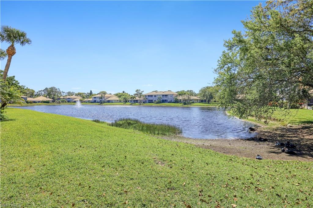 386 Emerald Bay Circle, Unit G4 Naples, FL 34110 - Photo 22 of 22 a view of a lake with houses in the back