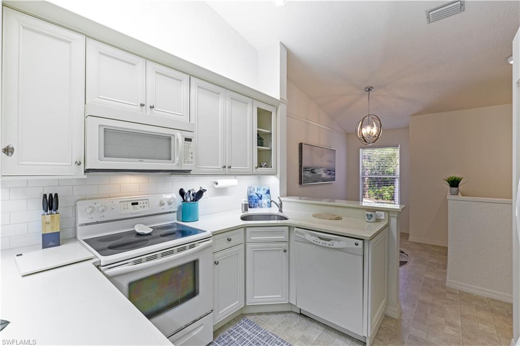 386 Emerald Bay Circle, Unit G4 Naples, FL 34110 - Photo 6 of 22 a kitchen with white cabinets and appliances