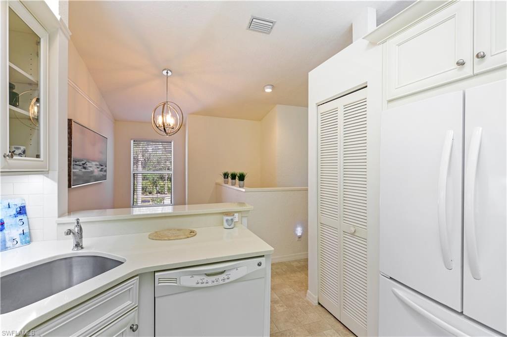 386 Emerald Bay Circle, Unit G4 Naples, FL 34110 - Photo 7 of 22 a view of a sink and dishwasher with wooden floor