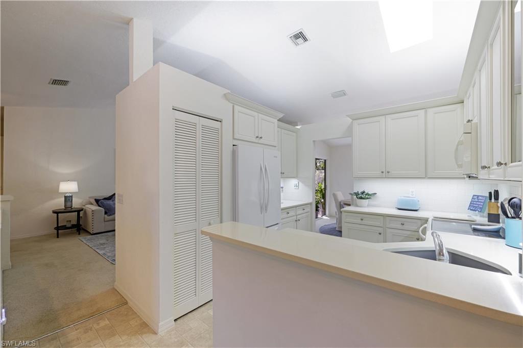 386 Emerald Bay Circle, Unit G4 Naples, FL 34110 - Photo 9 of 22 a kitchen with a sink and cabinets