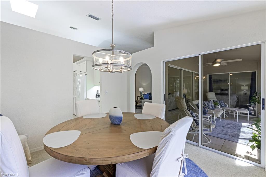 386 Emerald Bay Circle, Unit G4 Naples, FL 34110 - Photo 10 of 22 a view of a dining room with furniture wooden floor and chandelier