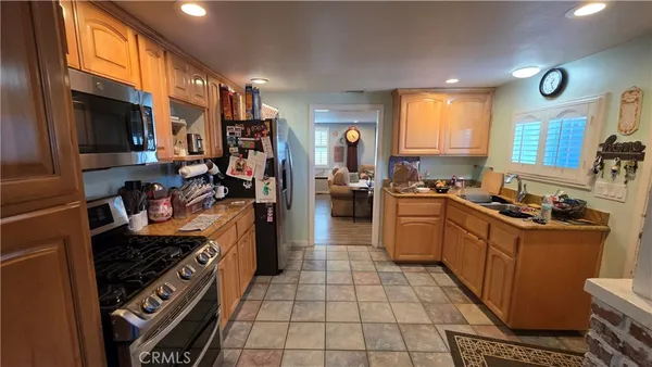 a kitchen with stainless steel appliances kitchen island granite countertop a stove a sink and a refrigerator