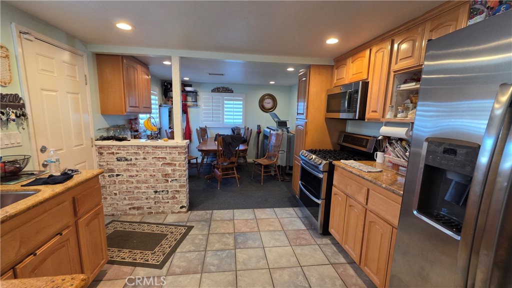1642 Fourth Street Norco, CA 92860 - Photo 18 of 35 a kitchen with stainless steel appliances kitchen island granite countertop a stove a sink and a refrigerator