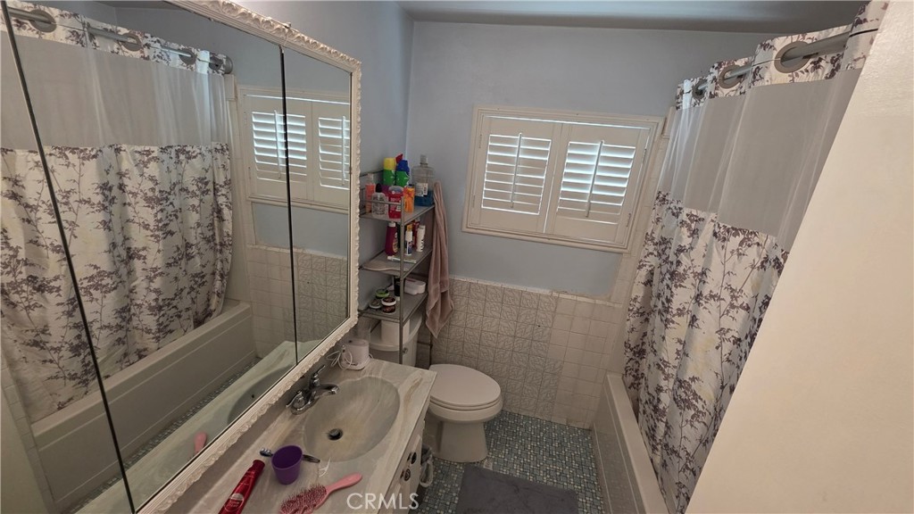 1642 Fourth Street Norco, CA 92860 - Photo 29 of 35 a bathroom with a shower curtain and a toilet