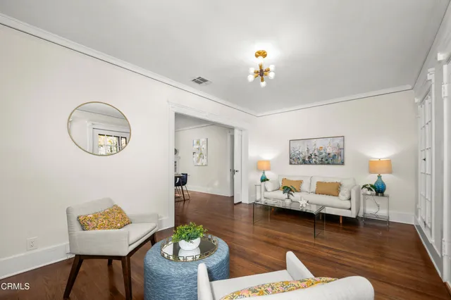 a living room with furniture and a wooden floor