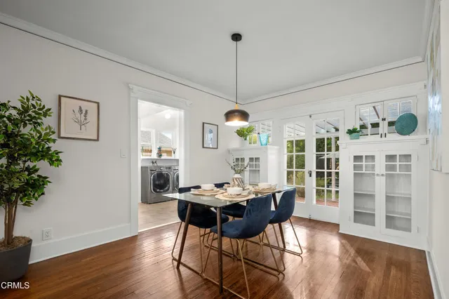 a dining room with furniture potted plants and wooden floor