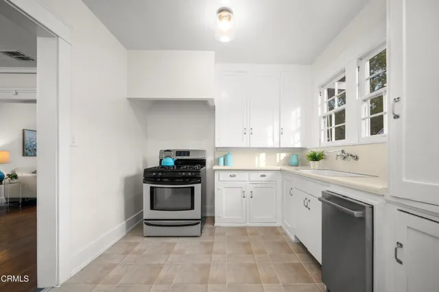 a kitchen with a stove sink and cabinets