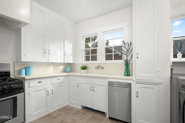 a kitchen with white cabinets and white appliances
