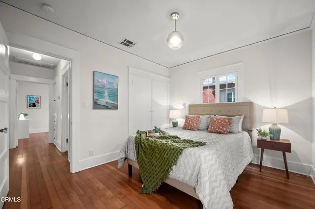 a bedroom with a bed and wooden floor