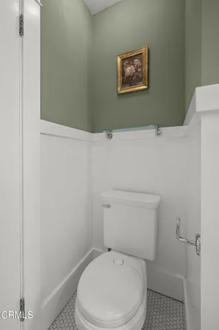 a white toilet sitting next to a white wall